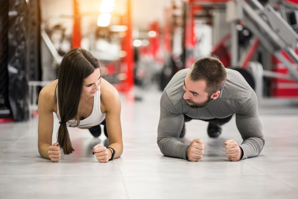 Mies ja nainen tekevät Plank-harjoituksen, joka on suunniteltu kaikille lihasryhmille